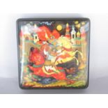 A late 20th century Russian lacquer box with a hand painted battle scene of two men fighting with