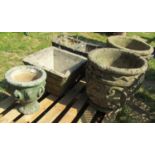 A pair of weathered cast composition stone circular garden urns with repeating C scroll geometric
