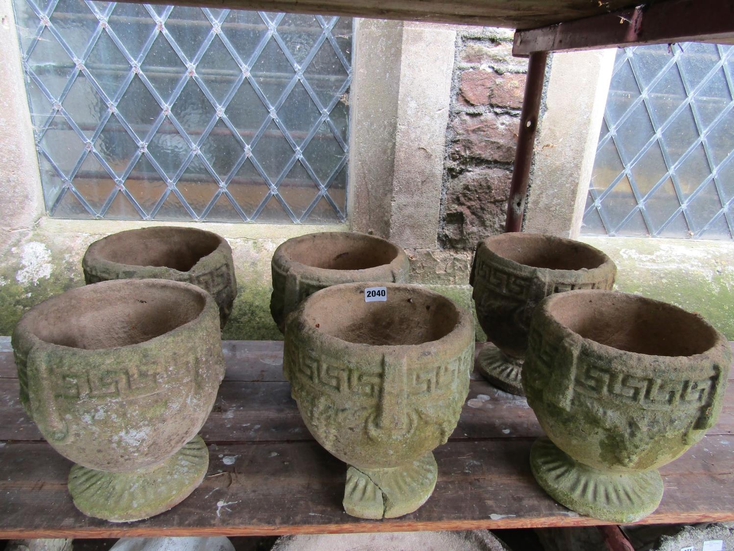 A set of six small weathered cast composition stone circular garden urns with Greek key, fixed