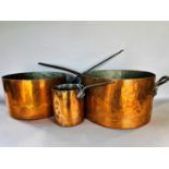 Three 19th century copper saucepans with cast iron handles and with old repairs, 31cm diam, 28.5cm