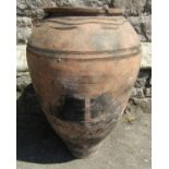 An old terracotta jar with simple incised detail, 62 cm high