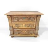 A miniature oak chest of with three carved panelled drawers, on bun feet, 30cm wide x 24cm high.