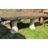A three sectional garden bench with rectangular thick natural stone top raised on a pair of cast