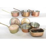 A mixed collection of six vintage brass and copper sauce pans of varying sizes, some covers, and a