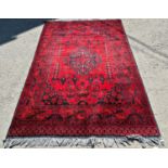 A Middle Eastern design carpet with a central stepped medallion with stylised flowers and urns on