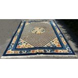 A Chinese wool carpet with a central circular medallion amongst a trellis of flowers and a floral