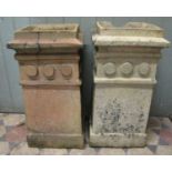 A pair of weathered buff coloured chimney pots with unusual repeating disc collars (probably