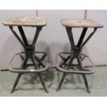 A pair of industrial stool or seat frames set on four splayed supports