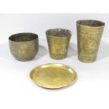 Three well worn Middle Eastern brass beakers each intricately engraved and a similar small plate