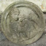 A weathered circular composition stone garden wall plaque with raised relief Madonna and child