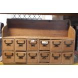 A vintage stripped oak bank of twelve small index drawers with brass flush fitting handles, 86 cm