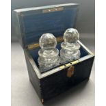 A leather domed travelling decanter case with a pair of small faceted glass decanters