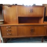 A G-Plan sideboard, the base enclosed by three drawers, with two cupboards, the raised back