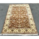 A Ziegler design carpet with scrolled flowers on a brown ground with running floral borders 181 cm x