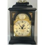 A Georgian bracket clock with ebonised case, the broken arch brass dial with silvered chapter