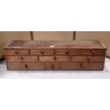 A vintage/nest of ten mahogany and stain pine drawers 88 cm wide x 24 cm deep x 22 cm high