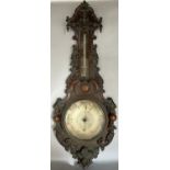 A good quality Victorian aneroid barometer with silvered dial, the casework with profusely carved