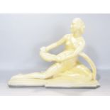 An art deco style plaster figurine of a young woman holding a bird in a yellow glazed finish, raised