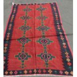 A South West Persian Qashqai Kilim, with two central columns, on a madder field, bearing signature