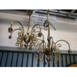 A pair of cast brass four branch hanging ceiling lights with long stems and scrolling foliate