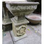 A weathered cast composition stone garden urn of square tapered form with rose relief collar