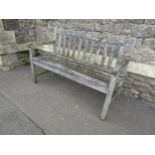 A well weathered vintage wooden teak two seat garden bench with slatted seat and back, 122cm wide (