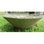 A weathered cast composition stone planter of squat conical form 78 cm diameter x 30 cm high