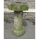 A weathered garden sundial, the circular plate with raised relief bird detail and pierced gnomon