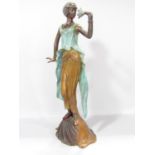 A French art deco style bronze female figure smelling a lily in a three tone bronze finish, 40cm