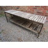 A painted and weathered heavy gauge iron framed garden potting table, with wooden slatted tiers,