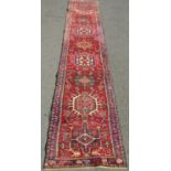 A Persian Runner, with multicoloured design, hand-knotted in pure wool, faded in areas, 330 x 64 cm