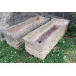 A pair of weathered cast composition stone rectangular flower troughs/planters with mock stone