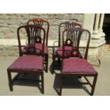 A set of four Georgian style mahogany comb back dining chairs with pierced quatrefoil splats over