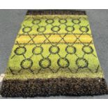 A retro shag pile carpet with green, yellow and flecked bands on a noughts and crosses pattern 205