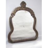 A Victorian shaped looking glass with a black lacquered frame with traces of gilded trailing leaves,