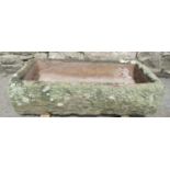 A weathered natural stone rectangular trough with dished interior, 76cm long x 37cm wide x 18cm deep