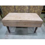 A Victorian pine drop leaf kitchen table on turned supports, 136cm long x 75cm wide when closed x