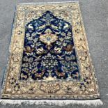 A Middle Eastern carpet with a garden scene of deer amongst flora on a dark blue ground 150 cm x 105