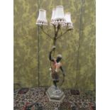 An Italian polychrome candelabra, the hexagonal base supporting a male character holding aloft a
