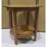 An arts and crafts style oak two tier occasional table of octagonal form with shaped apron, 53cm