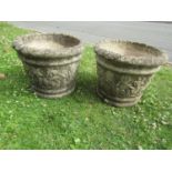 A pair of weathered cast composition stone garden planters of circular tapered form with rope