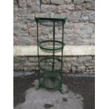 A green painted cast metal vegetable stand on four graduated removeable circular basket tiers with