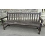 A good quality stained and weathered Gloster teak three seat garden bench with slatted seat and
