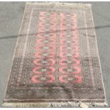 A Rose-Pink Princess Bokhara Rug with two central rows of guls and detailed borders bearing a