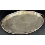 A large silver plated oval Edwardian drinks tray, with filigree galleried edge and a brass oval