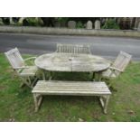 An associated suite of weathered teak garden furniture comprising a D end extending table with