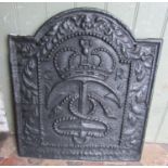 An old cast iron fire back with raised relief inverted anchor, crown, and further detail, 53cm