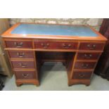 A reproduction kneehole twin pedestal desk fitted with eight frieze drawers disguised as nine on