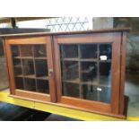 An Edwardian mahogany and pine cabinet enclosed by a pair of glazed panelled doors with pigeon holed