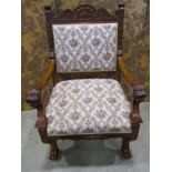 A Victorian carved oak open armchair with lions mask and foliate detail, upholstered seat and back